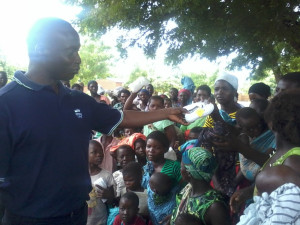 Aaron donating a pair of shoes to a girl